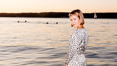 Die Autorin Caroline Wahl steht im Wasser eines Sees | Bild: Frederike Wetzels